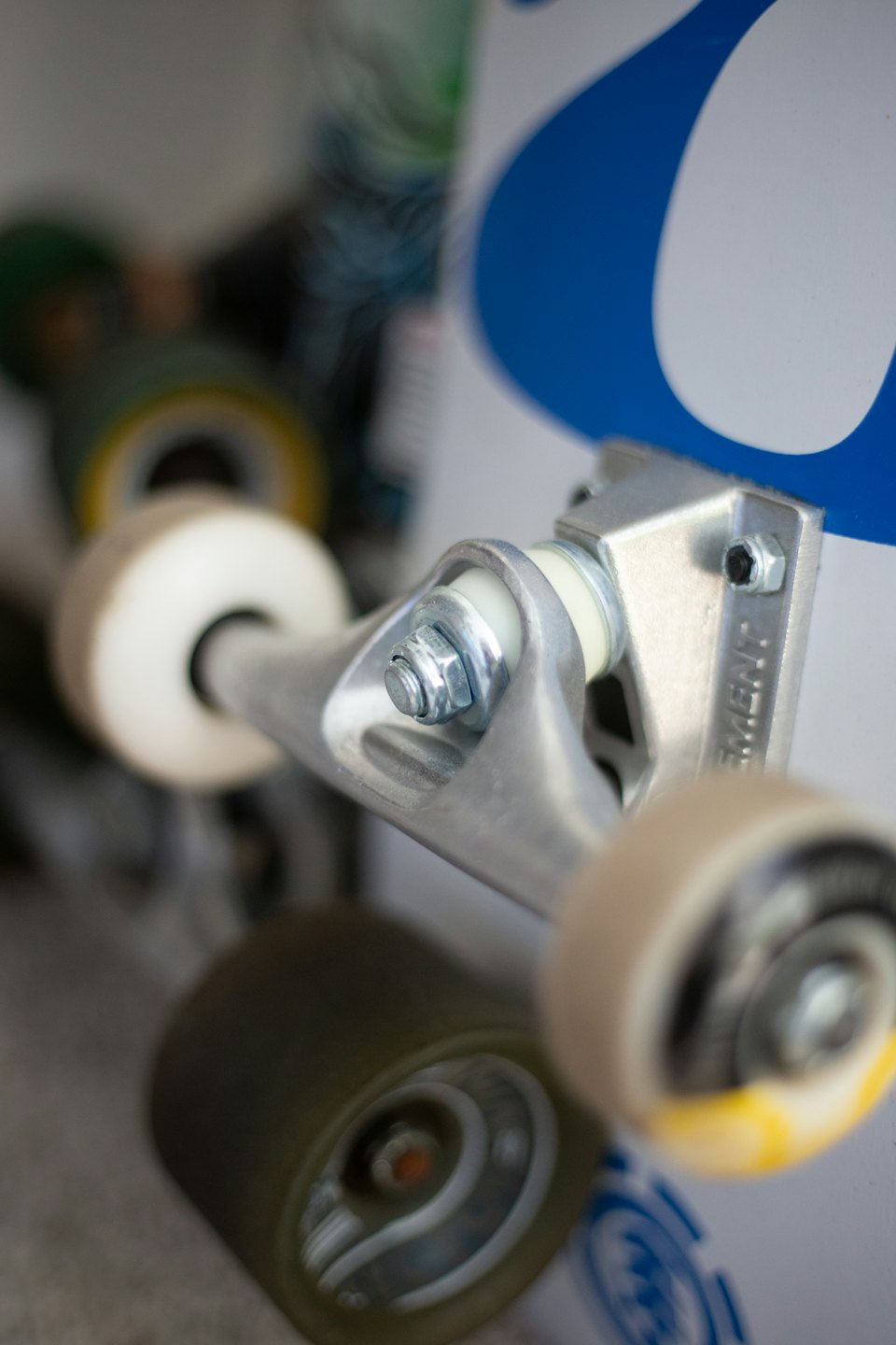 Carri argentati per skateboard con ruote color crema attaccati a una tavola.